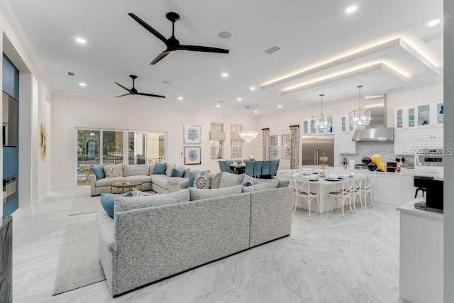 living room with ceiling fan with notable chandelier