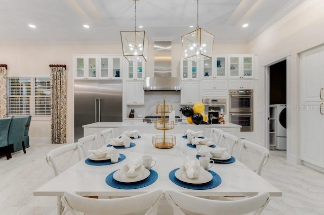 dining area with ornamental molding and washer / dryer