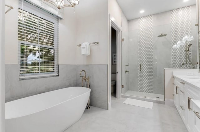 full bathroom featuring vanity, toilet, independent shower and bath, and tile walls