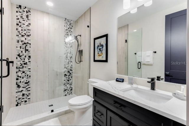 bathroom featuring vanity, an enclosed shower, and toilet