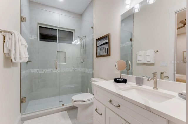 bathroom featuring vanity, an enclosed shower, and toilet