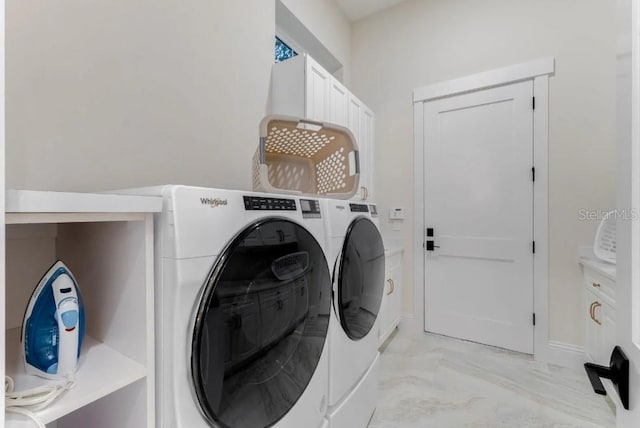 washroom with cabinets and washing machine and clothes dryer