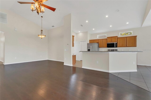 11530 57th Street Cir E, Parrish, FL 34219 - kitchen with appliances with stainless steel finishes, ceiling fan, brown cabinets, high vaulted ceiling, and baseboards