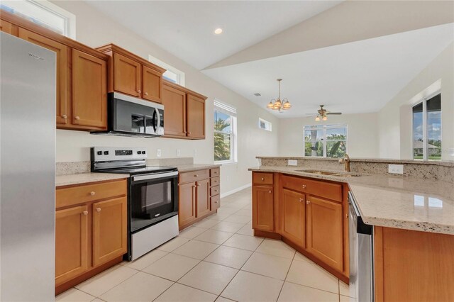 11530 57th Street Cir E, Parrish, FL 34219 - kitchen featuring appliances with stainless steel finishes, a sink, a chandelier, light tile patterned flooring, and light stone countertops