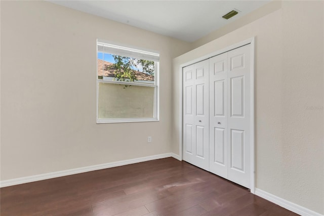 11530 57th Street Cir E, Parrish, FL 34219 - unfurnished bedroom featuring dark wood-style flooring, a closet, and baseboards