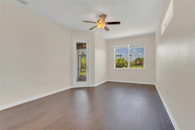 11530 57th Street Cir E, Parrish, FL 34219 - spare room featuring dark wood-type flooring, plenty of natural light, a ceiling fan, and baseboards