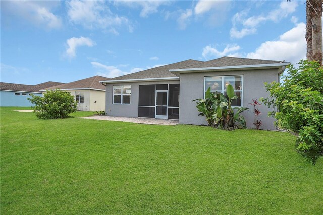 11530 57th Street Cir E, Parrish, FL 34219 - rear view of property with a lawn, stucco siding, a shingled roof, and a sunroom