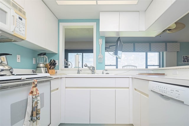 kitchen with white cabinetry, white appliances, a healthy amount of sunlight, and sink