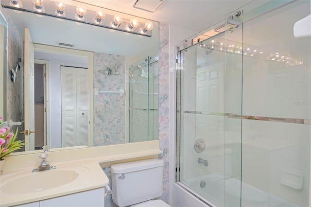 full bathroom featuring bath / shower combo with glass door, vanity, and toilet