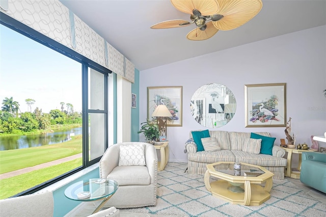 living room featuring lofted ceiling, ceiling fan, and a water view