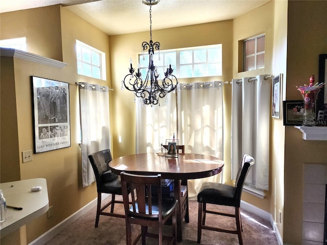 dining area with a chandelier, carpet, and a textured ceiling