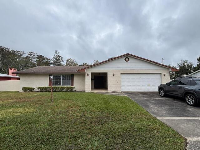 single story home featuring a garage and a front yard