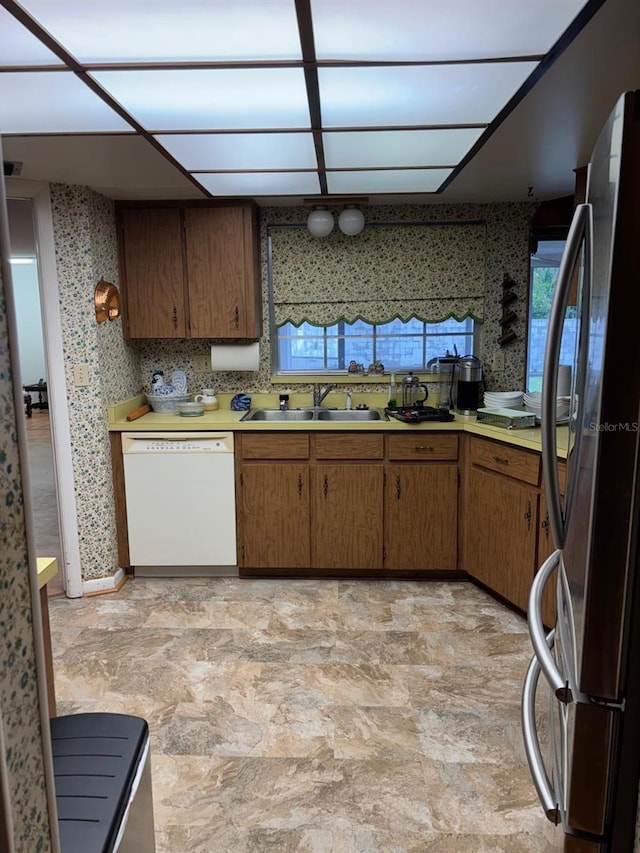 kitchen featuring stainless steel fridge, sink, and white dishwasher