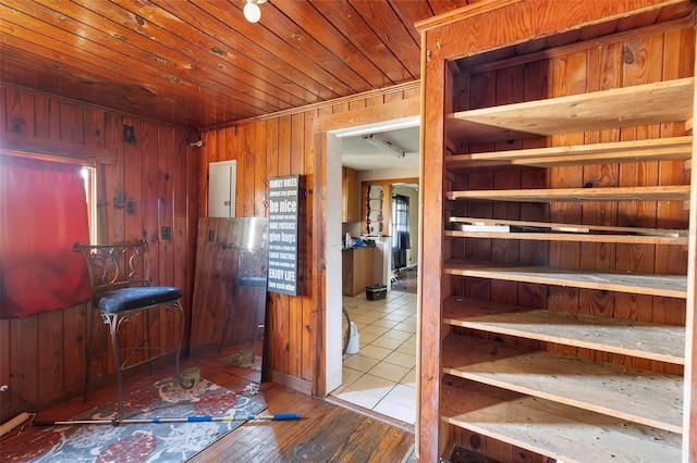 interior space featuring hardwood / wood-style floors, wood ceiling, electric panel, and wood walls