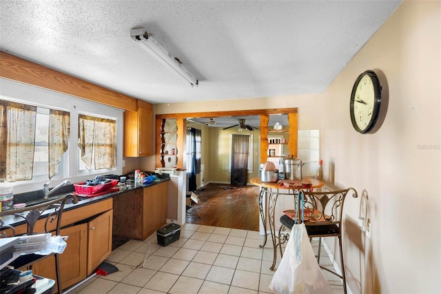 kitchen featuring light tile patterned floors, sink, a textured ceiling, and ceiling fan