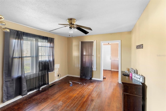 spare room with ceiling fan, dark hardwood / wood-style floors, and a textured ceiling