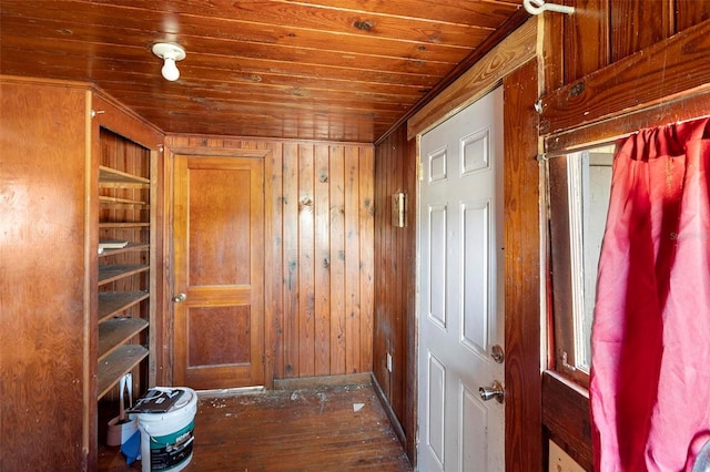 interior space with dark wood-type flooring, wood ceiling, and wood walls