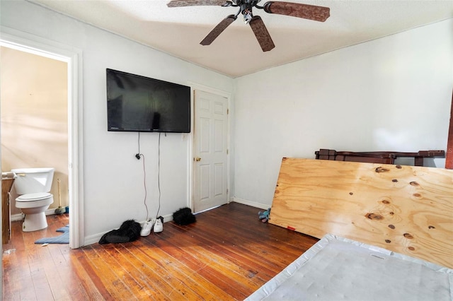 bedroom with ceiling fan, ensuite bath, and dark hardwood / wood-style flooring