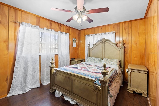 bedroom with ceiling fan, wooden walls, ornamental molding, and dark hardwood / wood-style floors