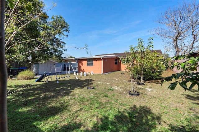 view of yard with a playground and a storage shed