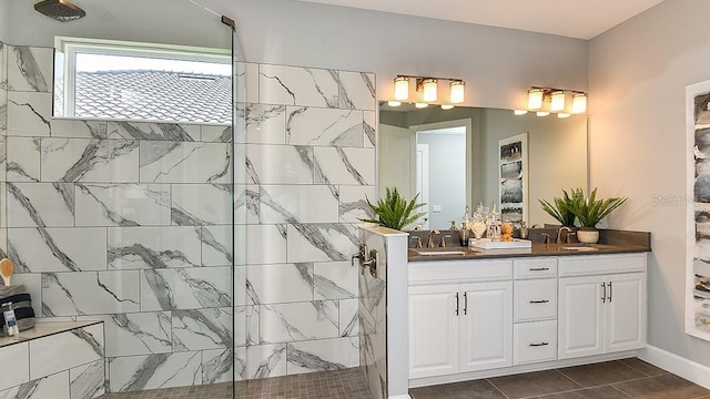 bathroom with tiled shower, vanity, and tile patterned flooring