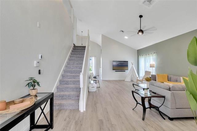 living room with ceiling fan, high vaulted ceiling, light wood-type flooring, and a wealth of natural light