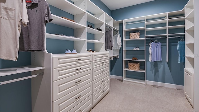 walk in closet featuring light colored carpet