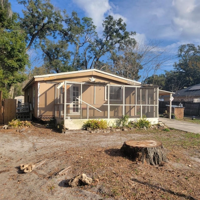 rear view of property featuring a sunroom