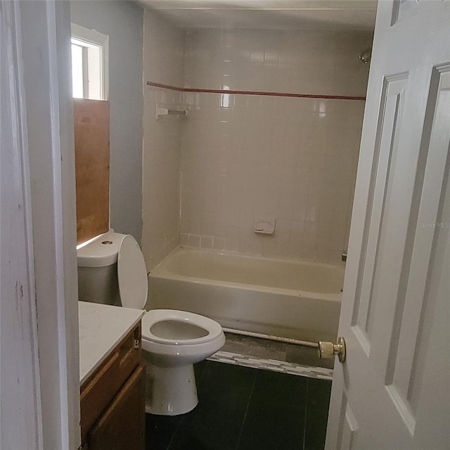 full bathroom featuring vanity, tiled shower / bath, tile patterned floors, and toilet