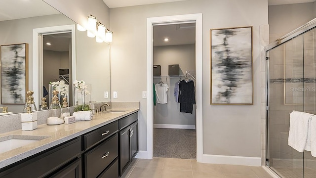 bathroom featuring tile patterned floors, a shower with shower door, and vanity