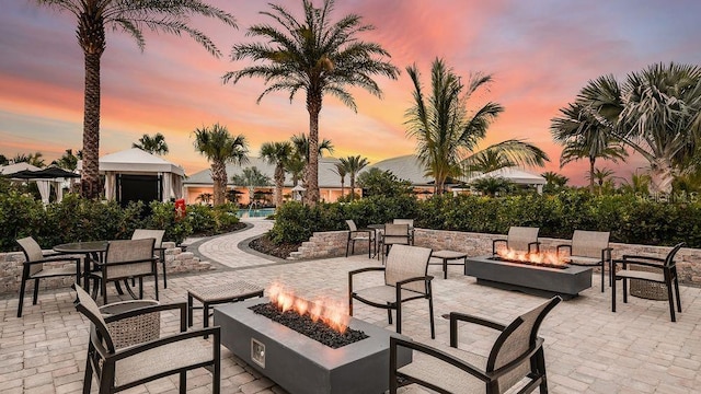 patio terrace at dusk featuring a fire pit