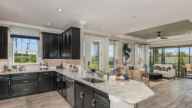 kitchen with tasteful backsplash, sink, light hardwood / wood-style flooring, and kitchen peninsula