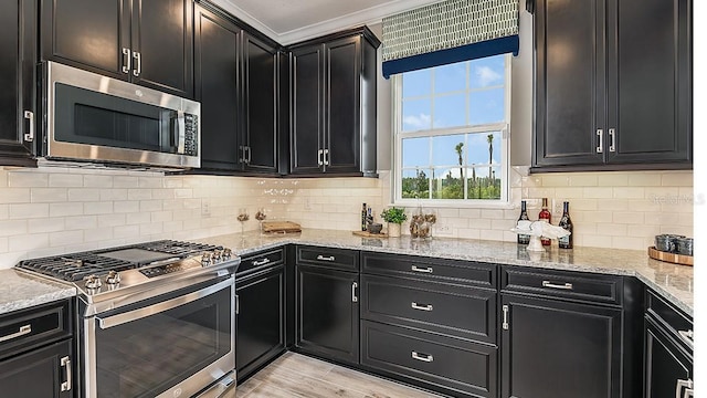 kitchen featuring crown molding, backsplash, stainless steel appliances, light stone counters, and light hardwood / wood-style floors