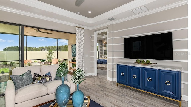 living room with crown molding, light hardwood / wood-style flooring, and ceiling fan