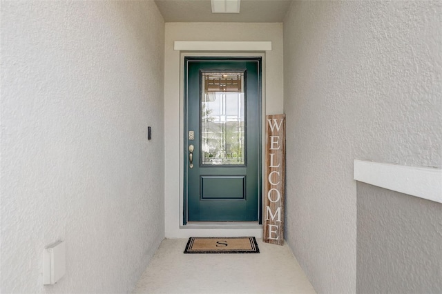 view of exterior entry featuring visible vents and stucco siding