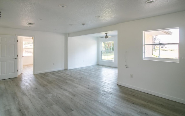 unfurnished room featuring ceiling fan, a textured ceiling, and light wood-type flooring