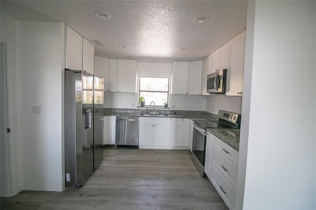 kitchen with white cabinetry, stainless steel appliances, and sink