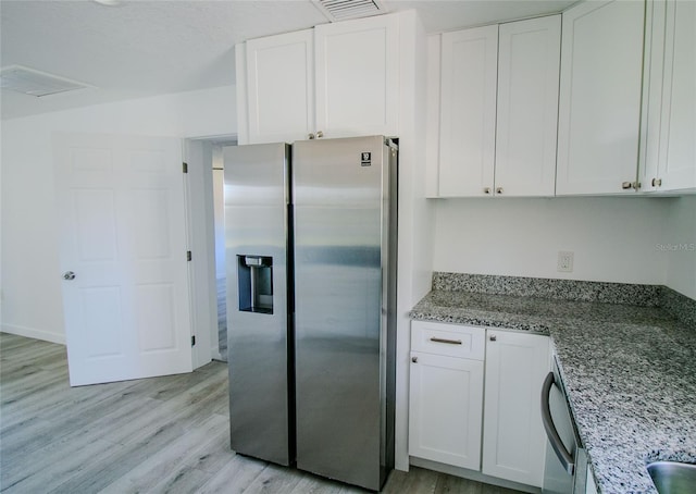 kitchen with stainless steel appliances, stone countertops, light hardwood / wood-style flooring, and white cabinets