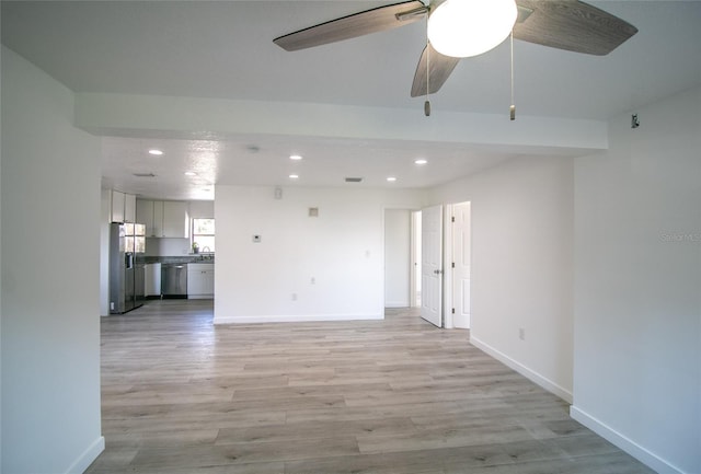 empty room with ceiling fan and light hardwood / wood-style floors