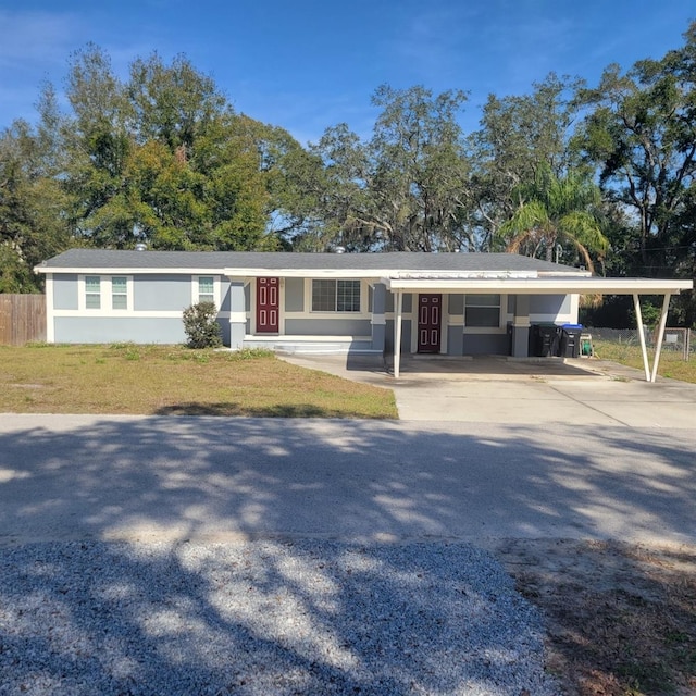 ranch-style home featuring a front lawn and a carport