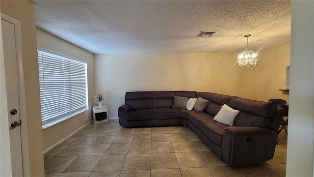 tiled living room featuring a chandelier and a textured ceiling