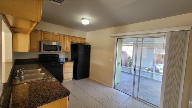 kitchen with light tile patterned floors, a sink, visible vents, light brown cabinetry, and black appliances