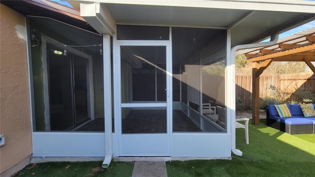 exterior space featuring a sunroom, a yard, fence, and stucco siding