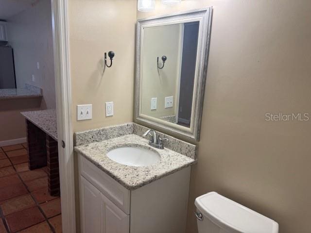 bathroom featuring tile patterned floors, vanity, and toilet