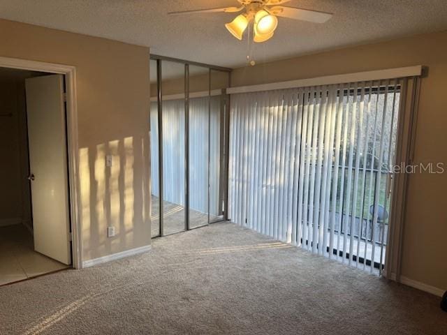 unfurnished room featuring ceiling fan, carpet, and a textured ceiling