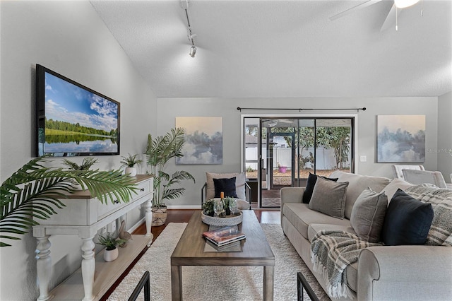 living room featuring vaulted ceiling, wood-type flooring, ceiling fan, track lighting, and a textured ceiling