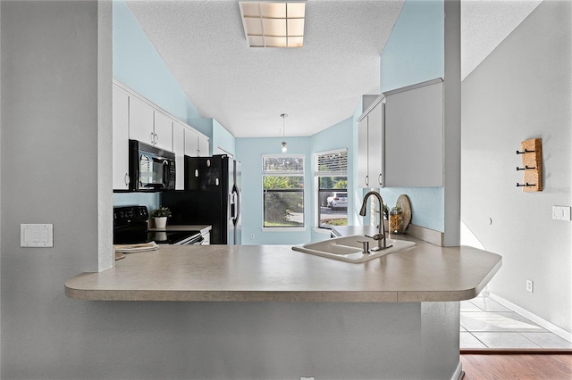 kitchen featuring black appliances, white cabinetry, sink, kitchen peninsula, and a textured ceiling