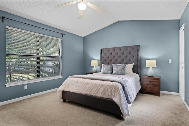 carpeted bedroom with ceiling fan, vaulted ceiling, and a textured ceiling