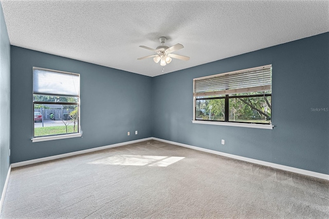 carpeted empty room with ceiling fan and a textured ceiling