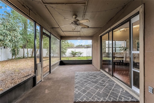 unfurnished sunroom with ceiling fan